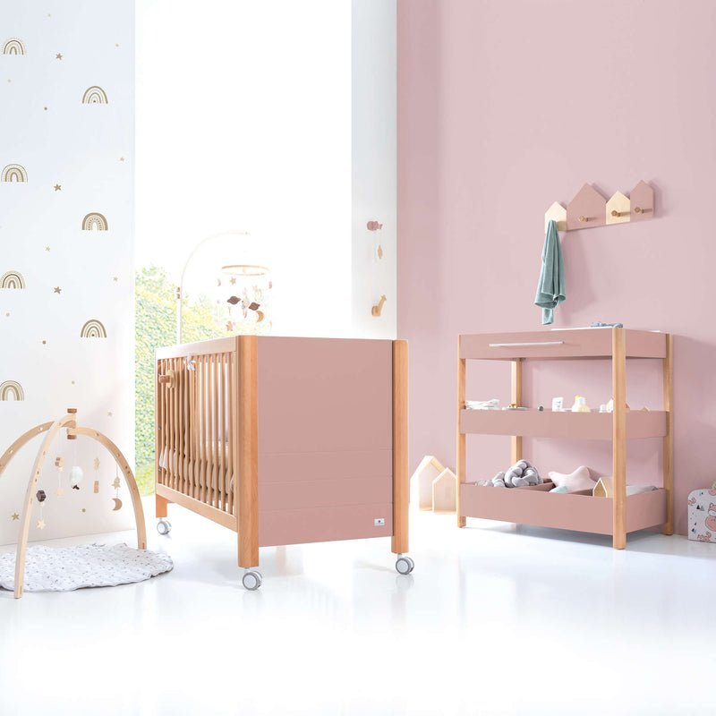 Habitación de bebé con cuna y cómoda cambiador en rosa y madera inspiración